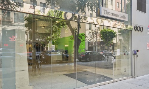 a glass front window with a street and cars outside