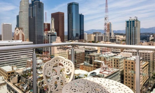 a table and chairs on a balcony overlooking a city