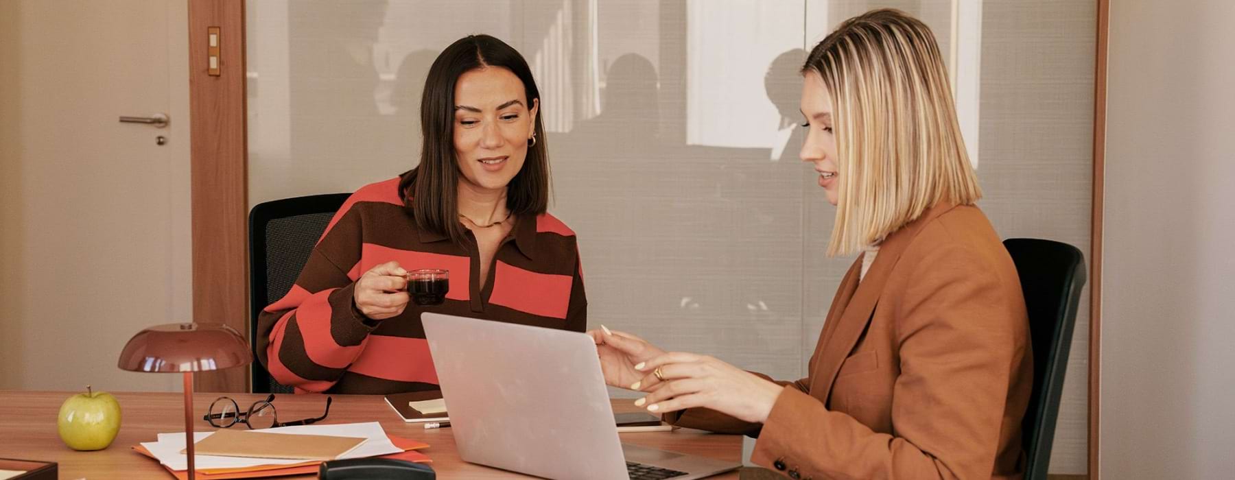 two woman working on a laptop